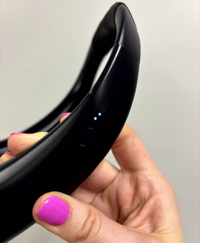 Side view of a black neck fan with a power indicator light
