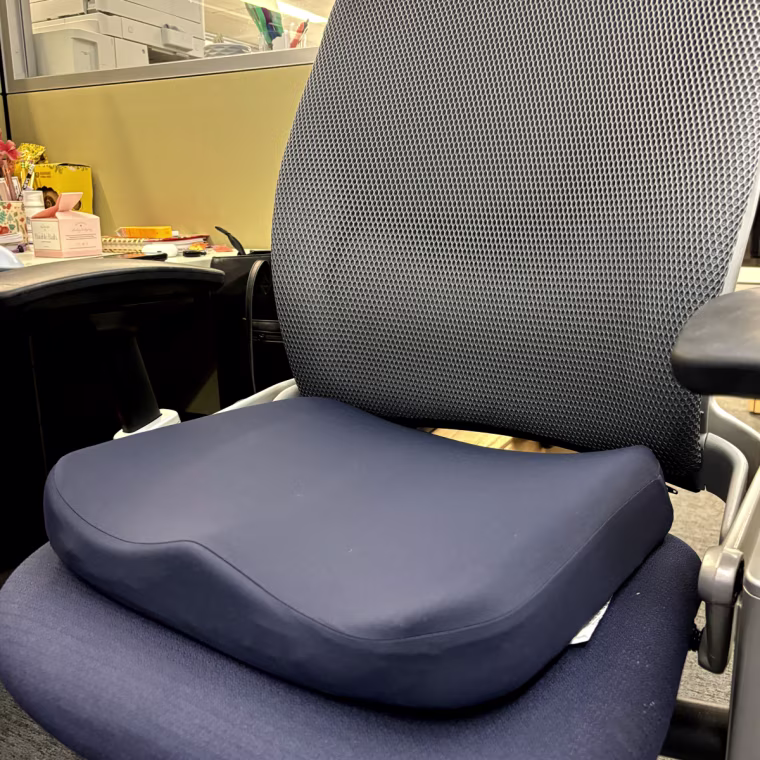 The dark navy blue Tempur-Pedic Seat Cushion in an office chair.