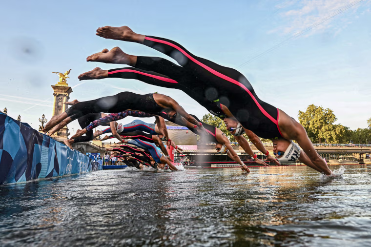 Athletes dive into the Seine river.