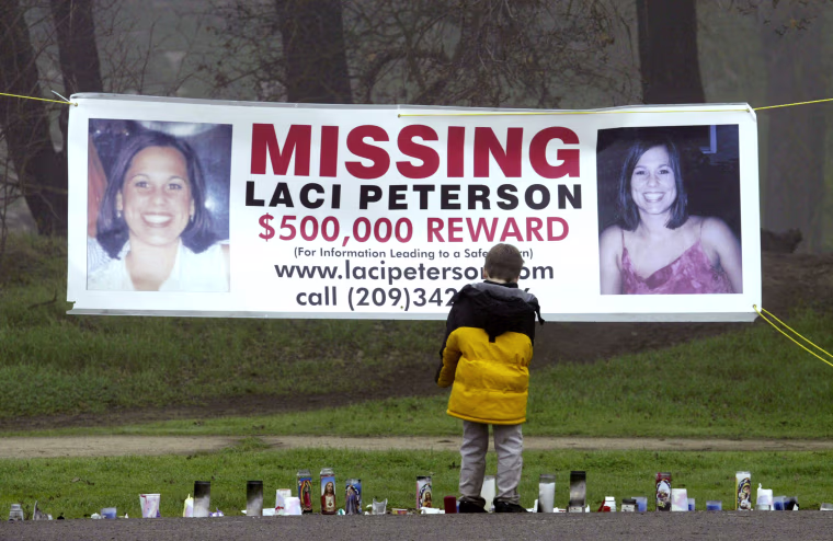 A young child looks at a makeshift memorial and a missing persons banner offering a $500,000 reward for information about Laci Peterson in Modesto, Calif., on Jan. 4, 2003. 
