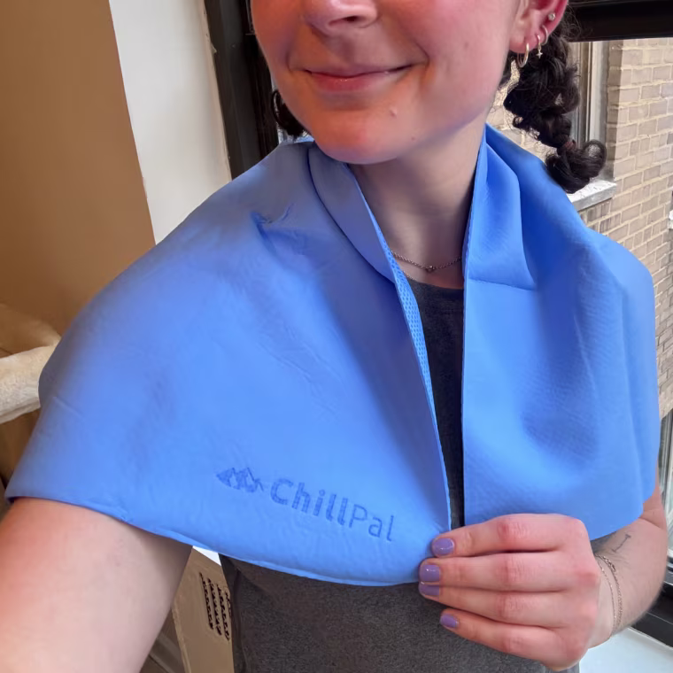 Woman wearing a Chillpal cooling towel over her shoulders