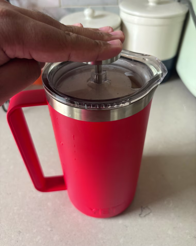 Man pressing down on the plunge in the Yeti French Press.
