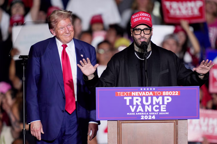 Donald Trump smiles as Nicky Jam speaks
