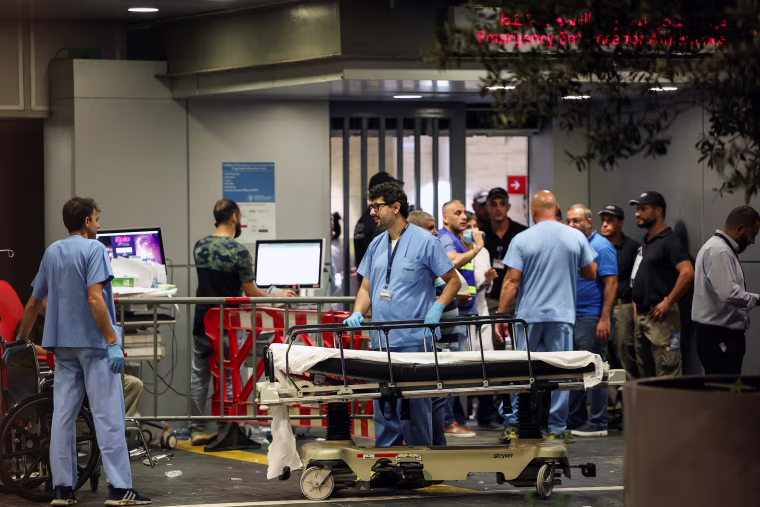 Hospital workers around an empty stretcher