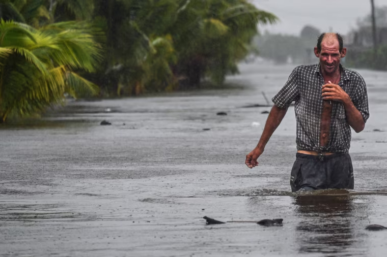 A man wades through water during a hurricane