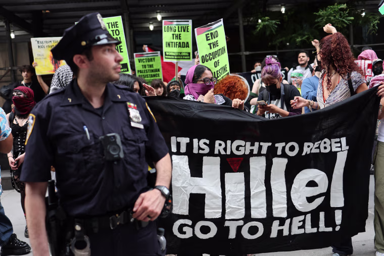 Protesters hold signs that read "It is right to rebel, Hillel Go to Hell"