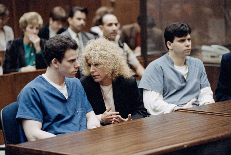Erik Menendez seated with his attorney, Leslie Abramson and his brother Lyle Menendez in a courtroom
