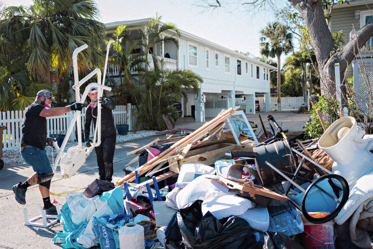 Ricky Brunette and Alex Bull remove a bathroom that was recently damaged in Hurricane Helene in Indian Rocks Beach, Fla., on Oct. 18, 2024.
