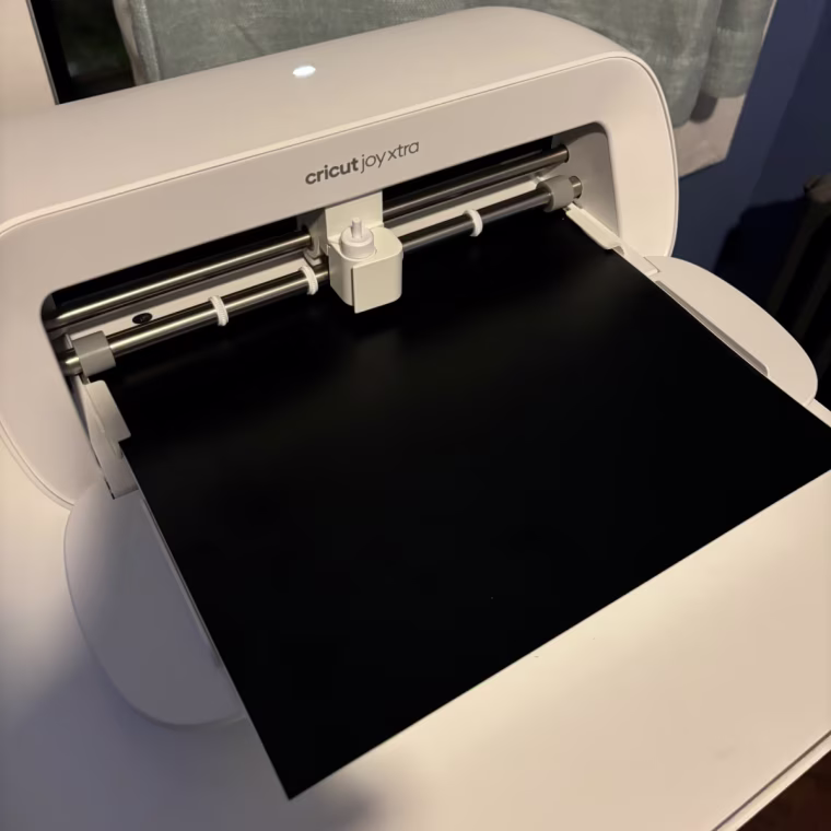 Cricut Joy Xtra sits on a desk with the front panel open.