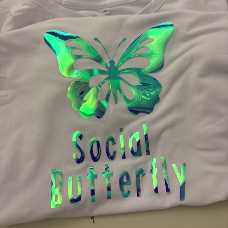 T-shirt with the words “social butterfly” ironed on the front and a butterfly on the top.