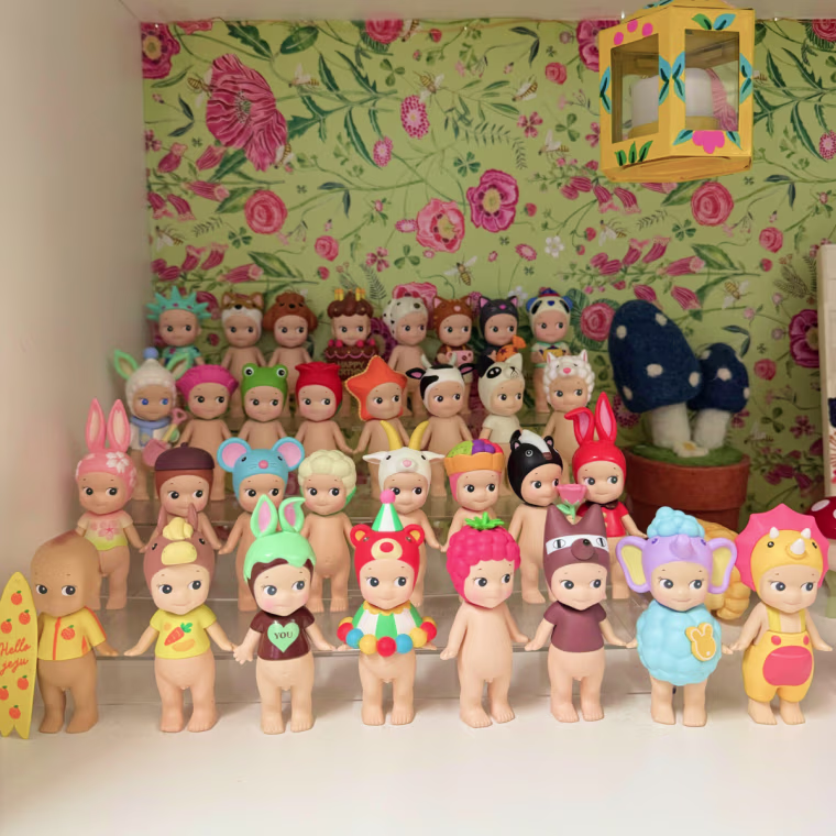 32 Sonny Angel figurines lined up in four rows of eight on a display stand.