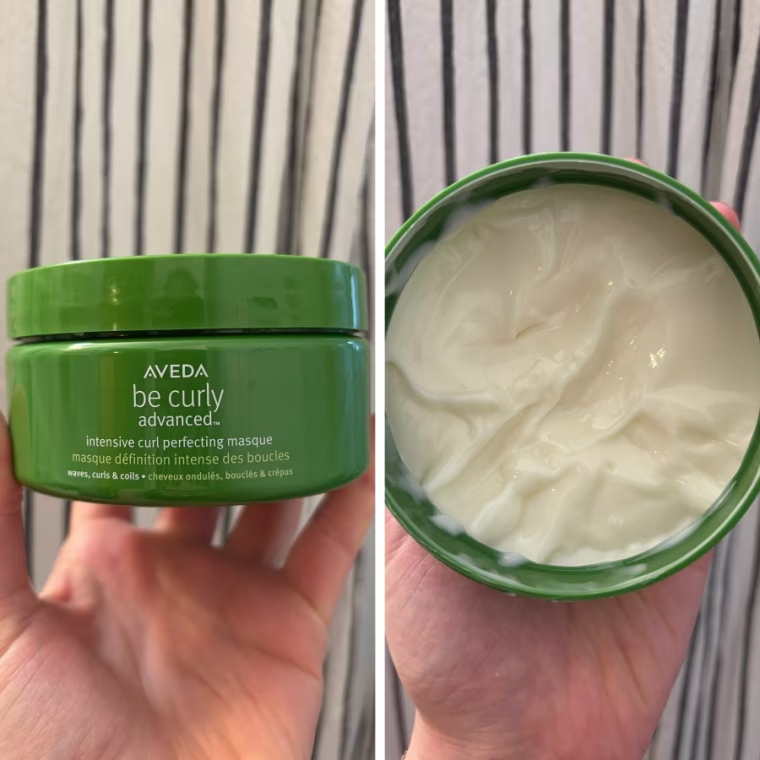On the left, a woman holds a closed Aveda Be Curly Advanced Intensive Curl Perfecting Masque container. On the right, she has the container open to show the white, creamy mask inside