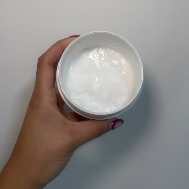 Woman holds open Crown Affair’s The Renewal Hair Mask.