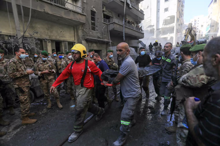 Lebanese army soldiers look on as rescuers remove the body of a victim extracted from the rubble of a levelled building, following an overnight Israeli airstrike on Nov. 23, 2024.