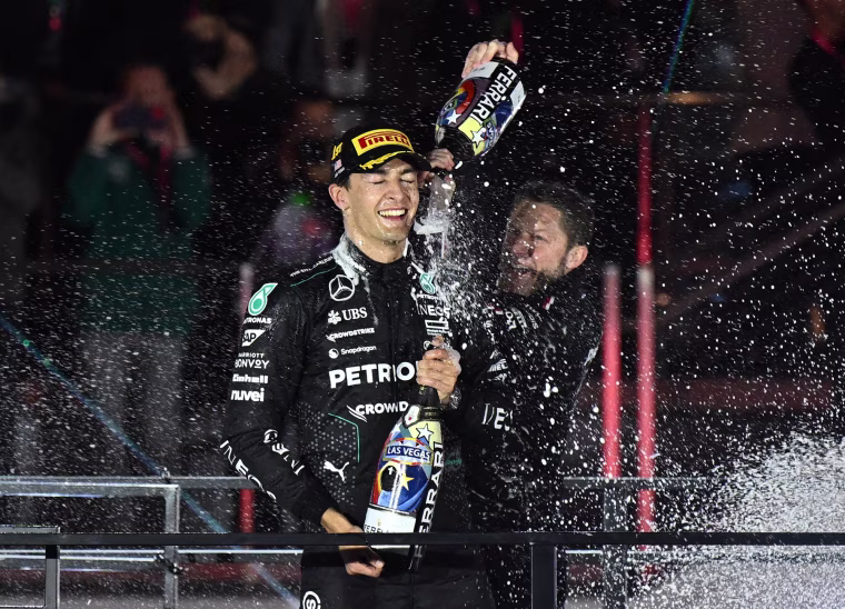 Mercedes' British driver George Russell celebrates on the podium