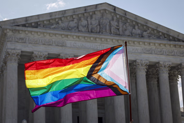 A person waves LGBTQ flag.