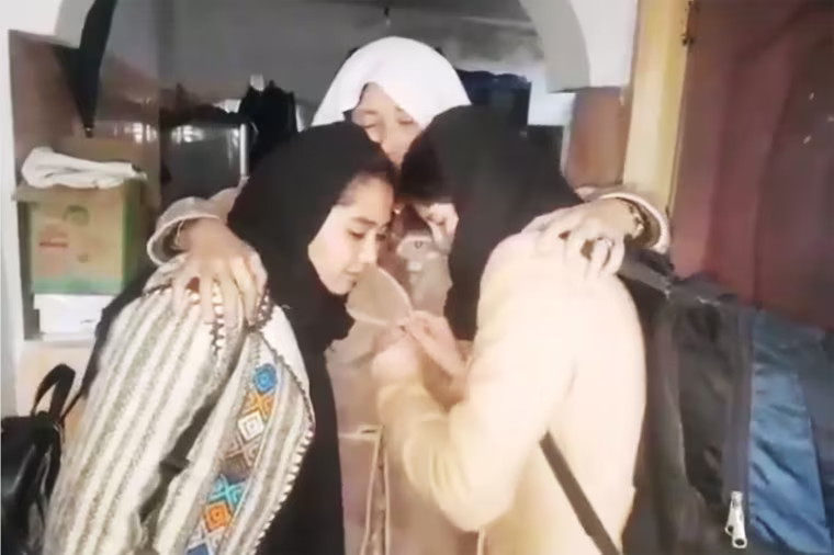 Cousins Farida and Zohra Ahmadi hug and kiss their grandmother goodbye, before fleeing Afghanistan in November 2021.