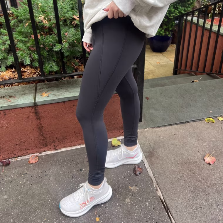 Woman wears a pair of Reebok Lux High Rise Legging while walking around.
