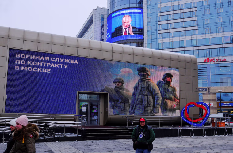 A screen shows a quote from Russian President Putin's annual press conference in Moscow
