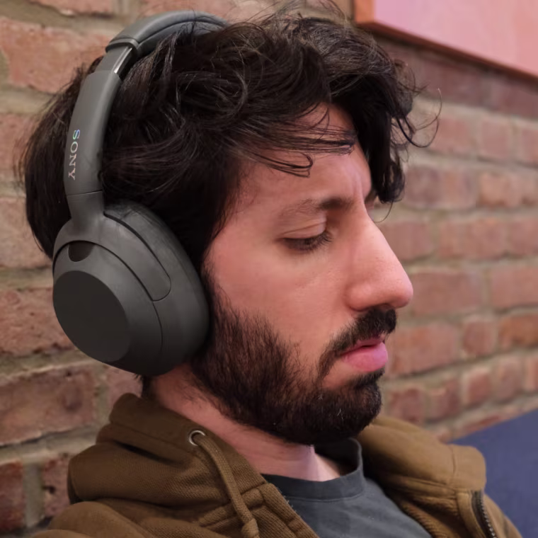 Close up shot of the writer wearing the Sony Ult Wear headphones against a brick background.