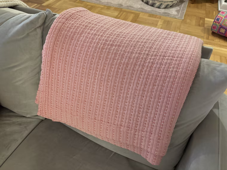 Malin and her cats love laying with the Brooklinen grid-knit throw blanket on her sofa.