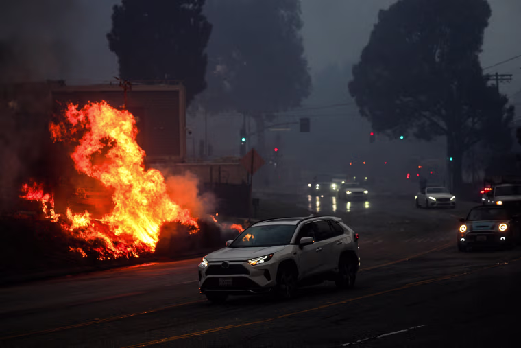 Image: A brush fire burns near homes in Pacific Palisades