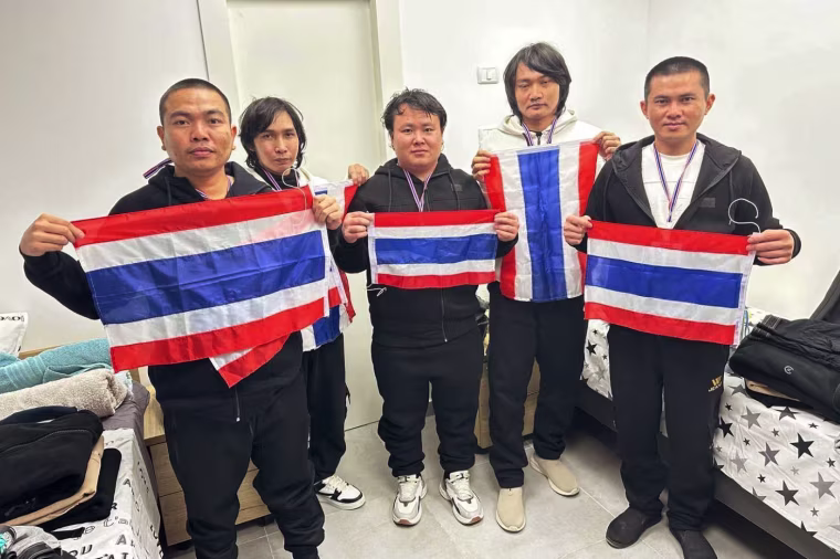 Released Thai hostages hold up Thai flags 
