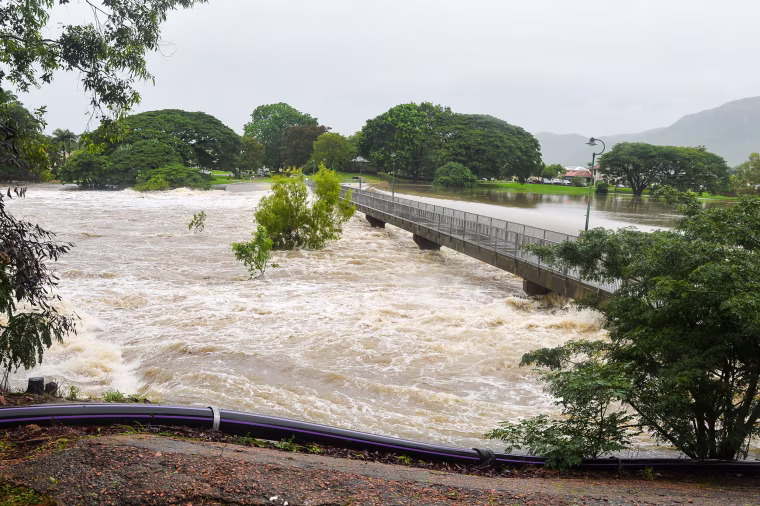Floods are engulfing northeast Queensland, with residents in parts of Townsville told to evacuate following warnings water levels could reach the second storey of some buildings. Residents watch water flow over Aplin’s Weir in Mundingburra. 