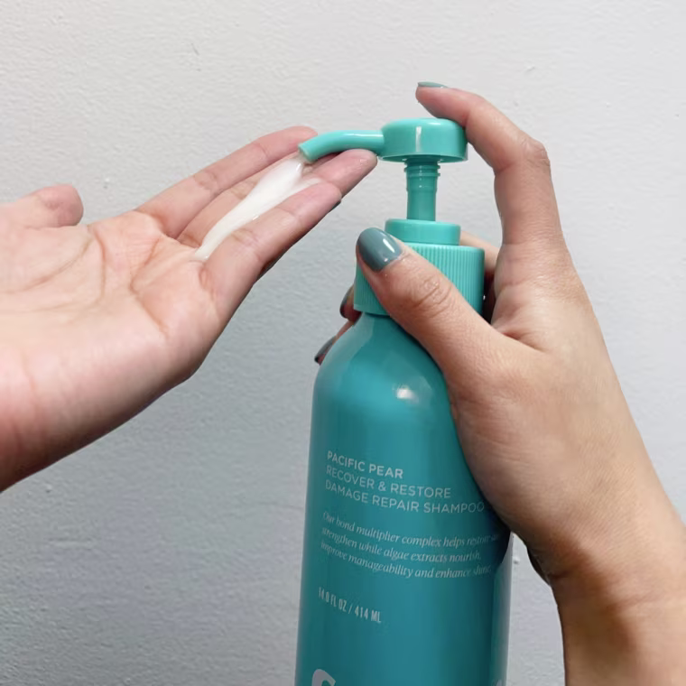 Woman dispenses Saltair Recover & Restore Damage Repair Shampoo into her hand.