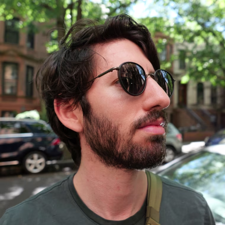 A headshot of the writer wearing black sunglasses, looking away to the right of the camera.