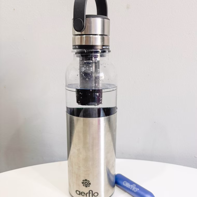 Aerflo Aer 1 bottle sitting on a countertop with a blue capsule beside it.