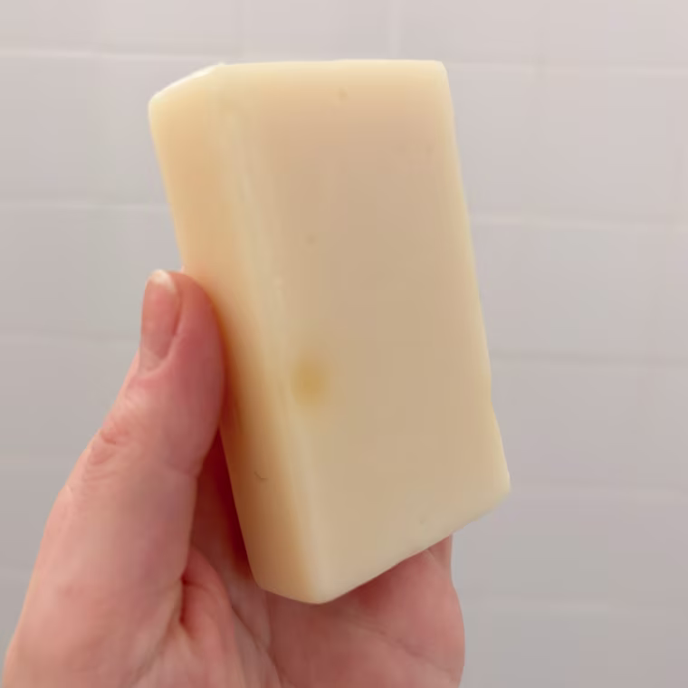 Person holding bar of Megababe shave soap bar.