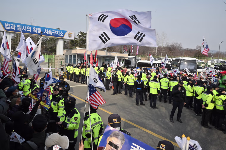 Supporters of arrested and impeached South Korean President Yoon Suk Yeol wave the national flags as they gather outside the Seoul Detention Center in Uiwang on March 7, 2025. 