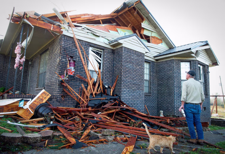 Kerry Walker checks damage to his home in near Plantersville, Ala., after a tornado