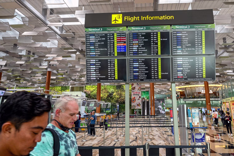 A departure board at Singapore Changi Airport shows a cancelled flight to London Heathrow on March 21, 2025.