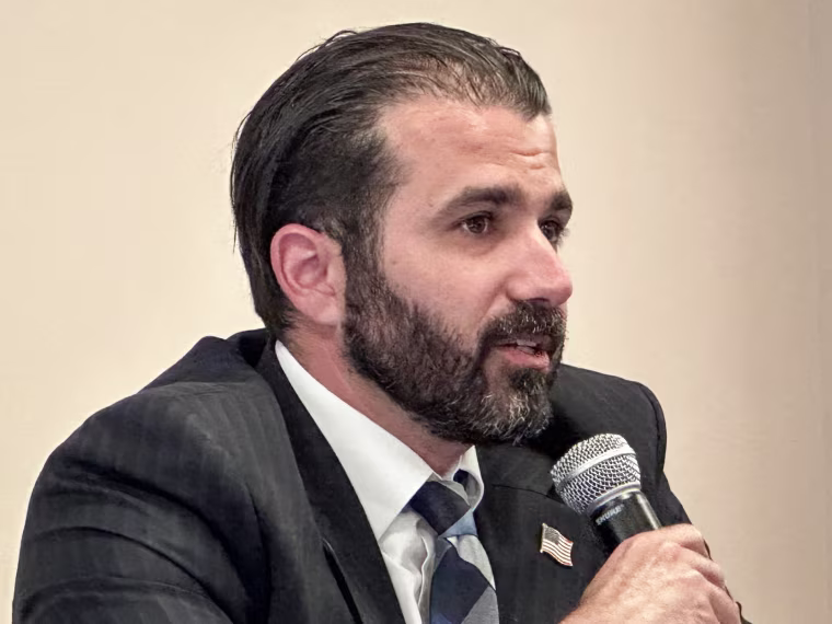 Josh Weil speaks into a microphone he's holding