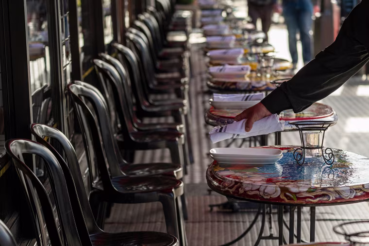 A restaurant worker puts down napkins