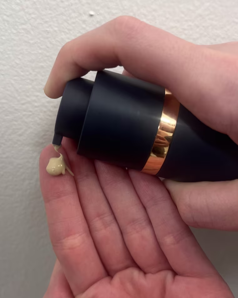 Woman pumps Skinbetter Science AlphaRet Overnight Cream into her hand.