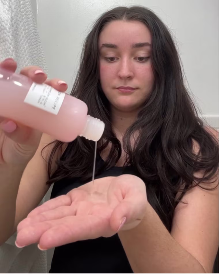 A woman dispenses the Glow Recipe Watermelon Glow Toner in her hand.