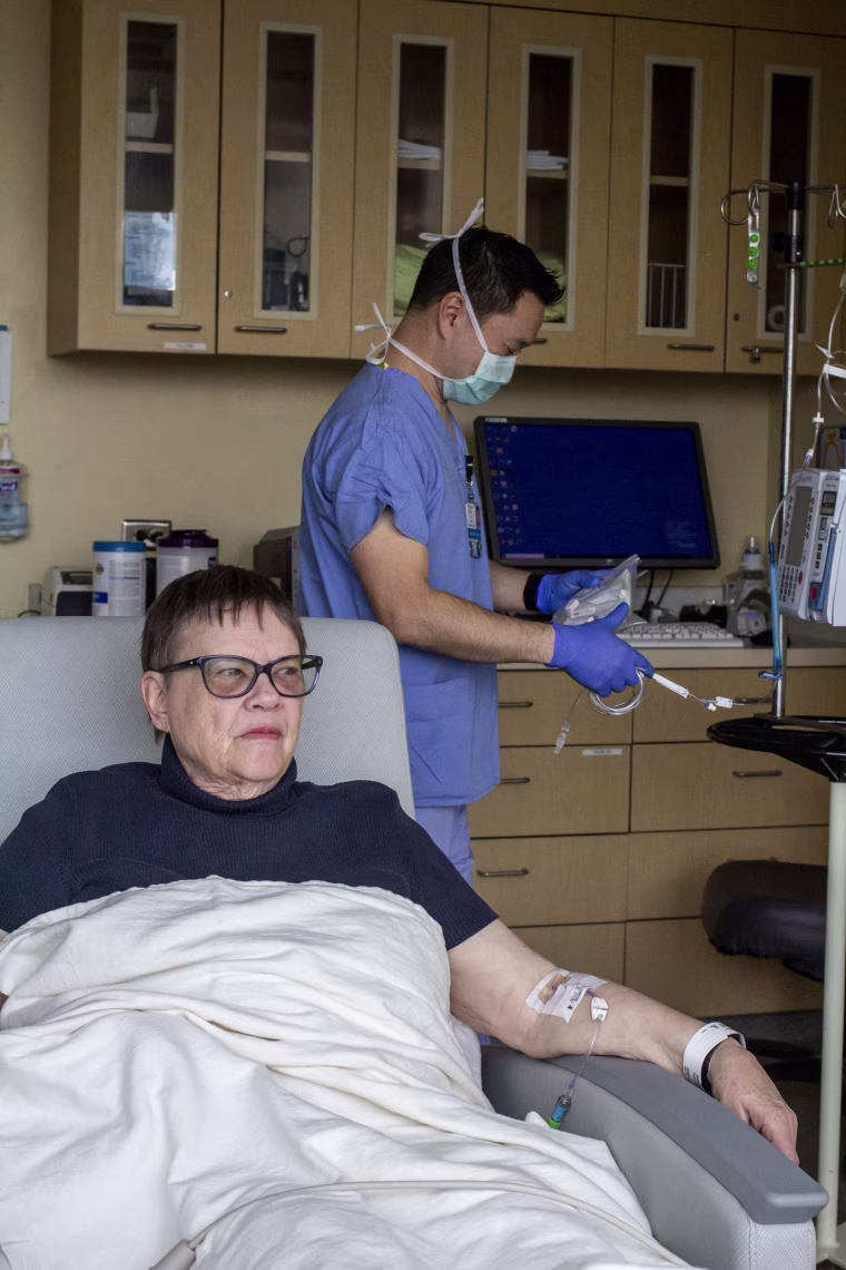 Andrea Gilbert prepares to receive an infusion of lecanemab that is being prepared by registered nurse Jeff Chun. “It’s just something you have to face,” Gilbert said of her Alzheimer’s diagnosis. “Life goes on and it’s pretty good.”