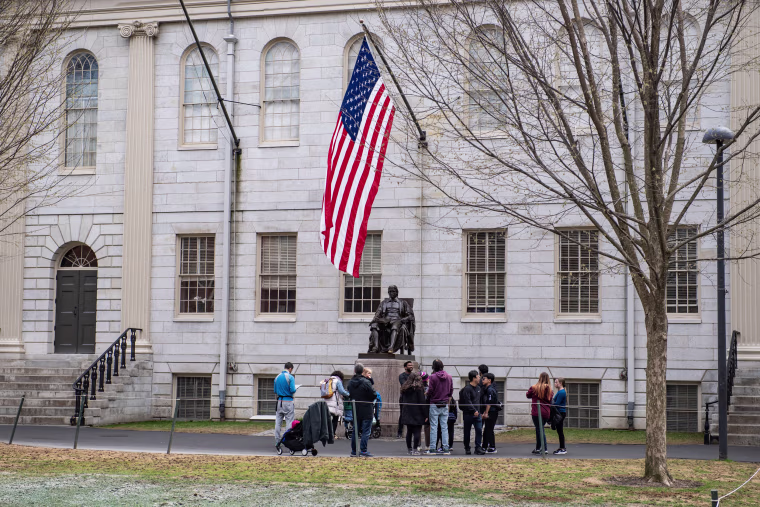 Image: People gather around the John Harvard Statue on the Harvard University campus