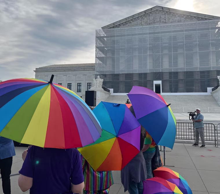 Activists carry rainbow umbrellas outside the Supreme Court on April 21, 2025.