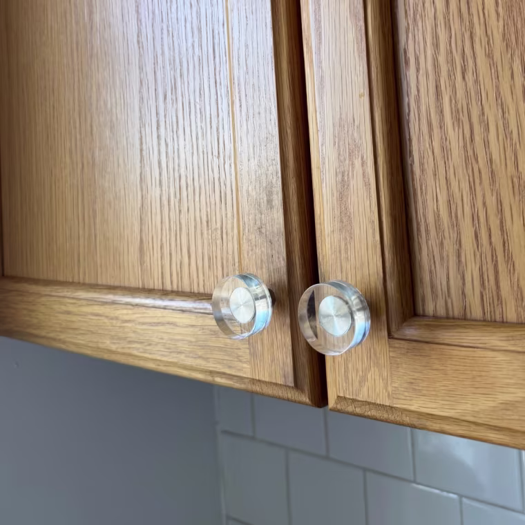 Clear glass knobs on wooden cabinets.