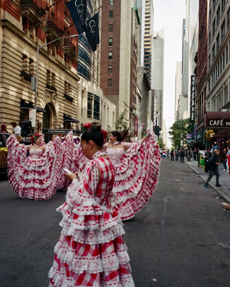 A photo of women wearing red and white dresses practicing for the 60th annual Hispanic Day Parade in New York City.