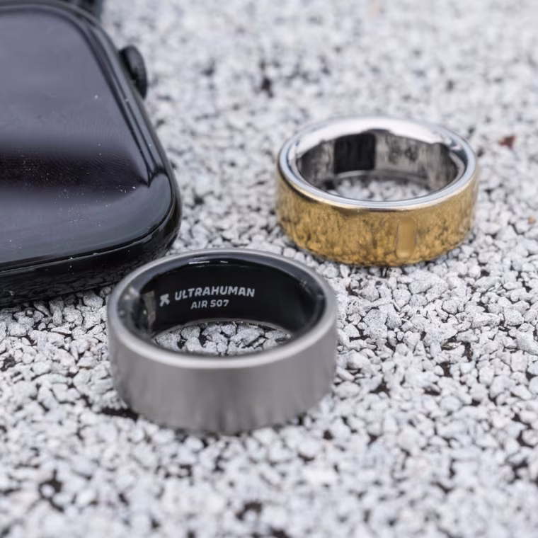 A close up of the Ultrahuman Ring Air in front of the Oura Ring 4 and Apple Watch Series 10.