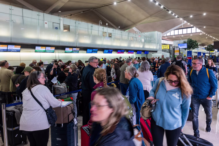 People wait in line for a delayed flight