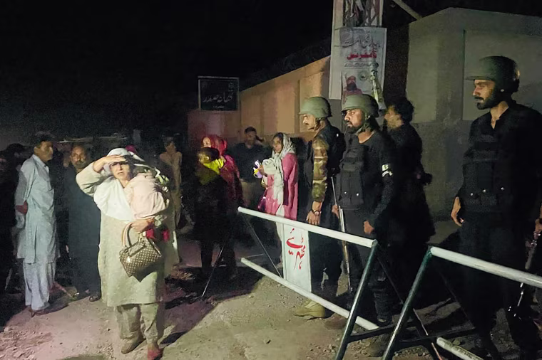 Security personnel cordon-off a street as local residents evacuate their homes near the site of a strike in Muzaffarabad