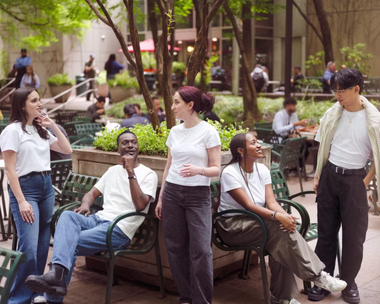 A group of NBC Select editors wearing a variety of white t-shirts in a public park.