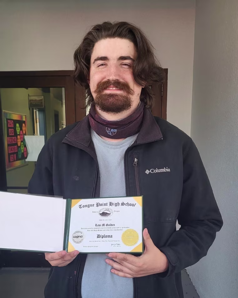 Levi Golden holding his diploma.