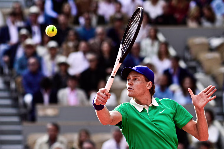 Jannik Sinner plays a backhand return on the tennis court